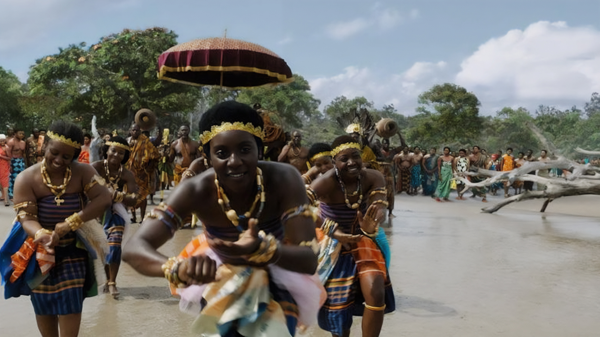 group of dancers look joyously into camera as they parade down the street