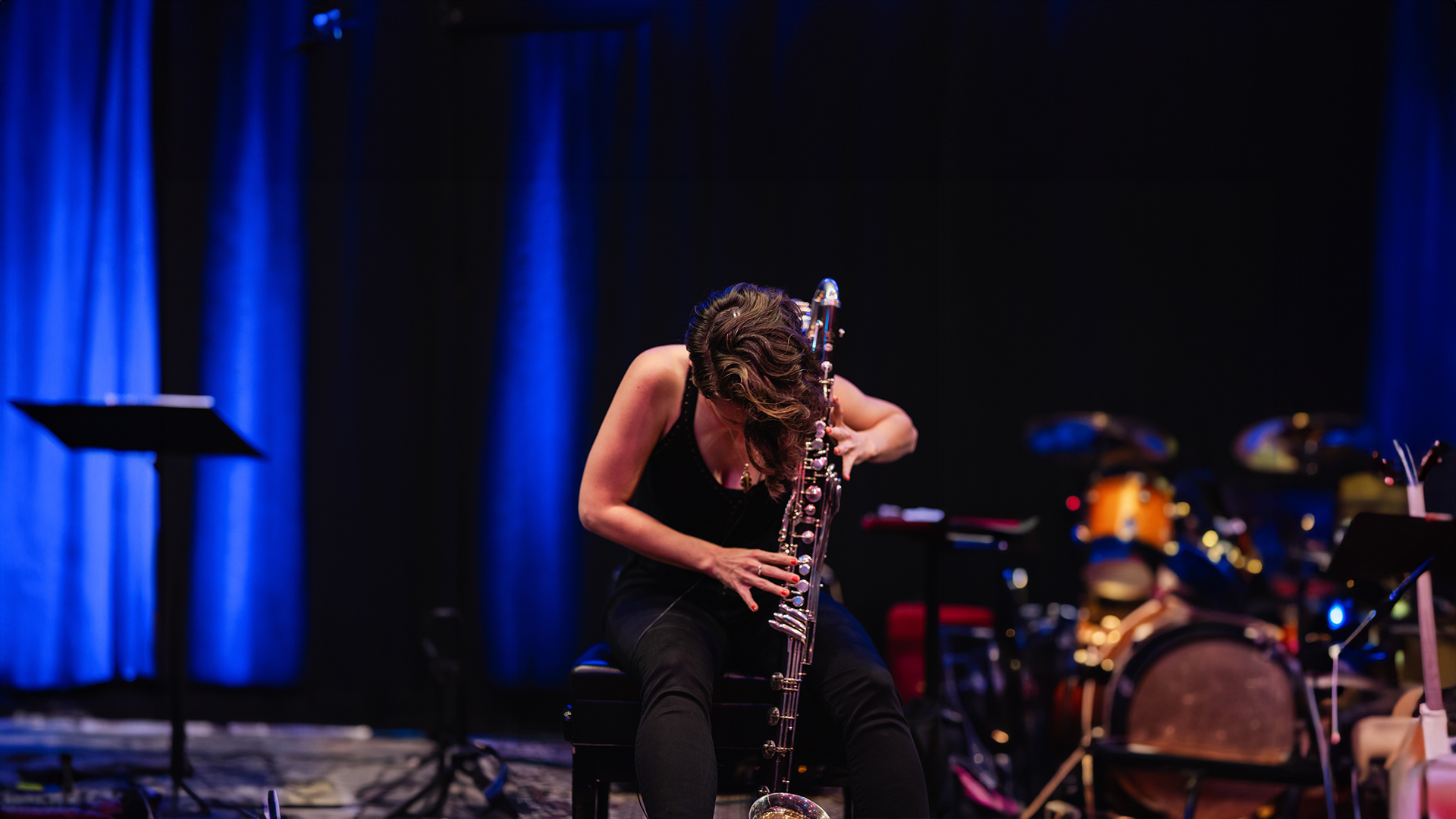 person playing base clarinet passionately on stage