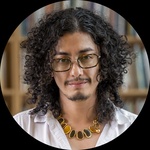 A Latinx / Queen non-binary person Pronouns : they/them or an. They have Long curly brown hair Brown eyes