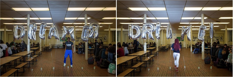  A black young man and woman, standing in a high school among silver letter balloons that spell DREAMER. 