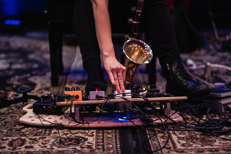  hand reaches down to adjust peddle board attached to electronic bass clarinet 