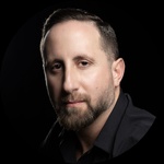 White/Queer Masc Person Man with a beard wearing a black shirt  Short brown hair Brown eyes