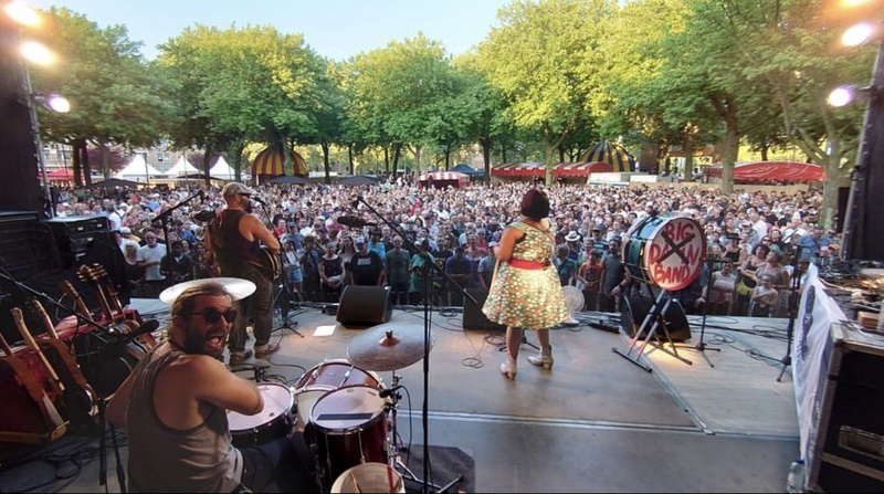  A band plays on stage at an outdoor music festival. 
