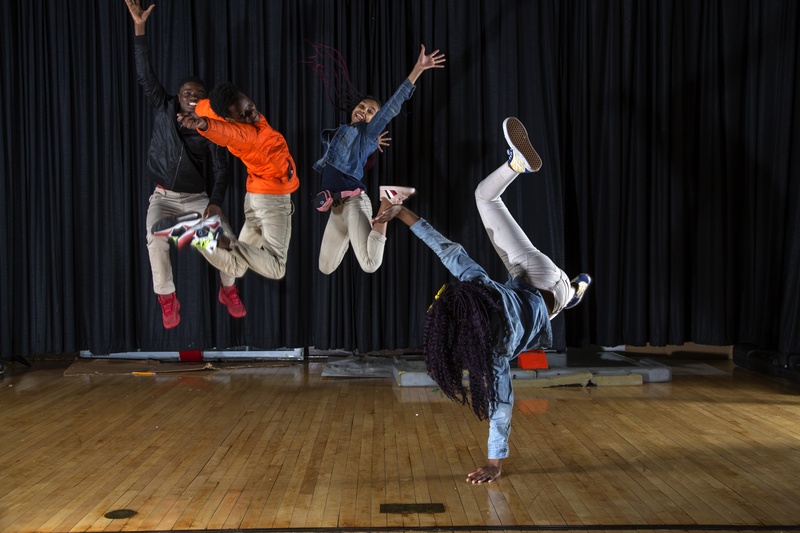  Photograph of four exuberant students caught in mid-air. 