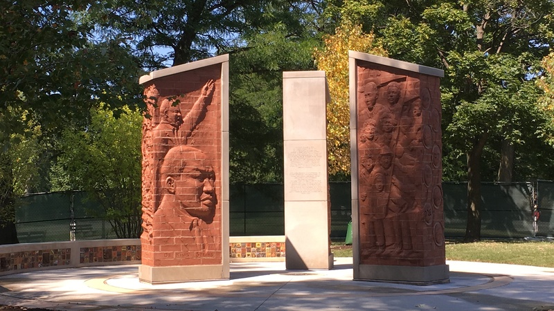  Oratory King and MLK in profile on left stele. Peaceful marchers and counter protestors on the right stele 