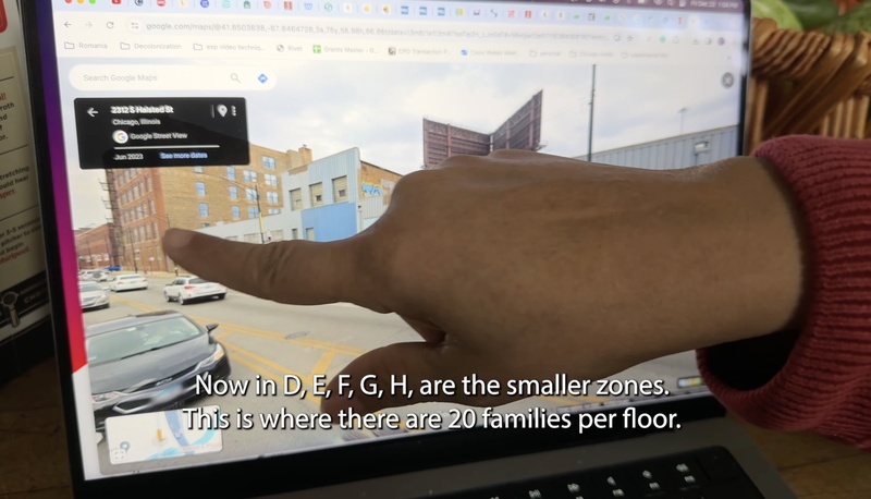  Closeup of a hand pointing to an industrial warehouse on a googlemap streetview. Caption reads "This is where there are 20 families per floor" 